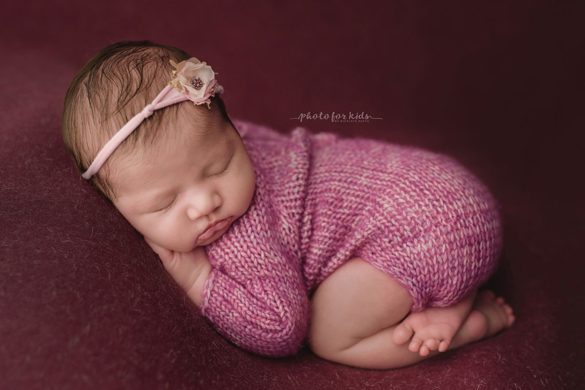 New born girl in pink dress sleeps during a new born workshop by Nicoleta Raftu