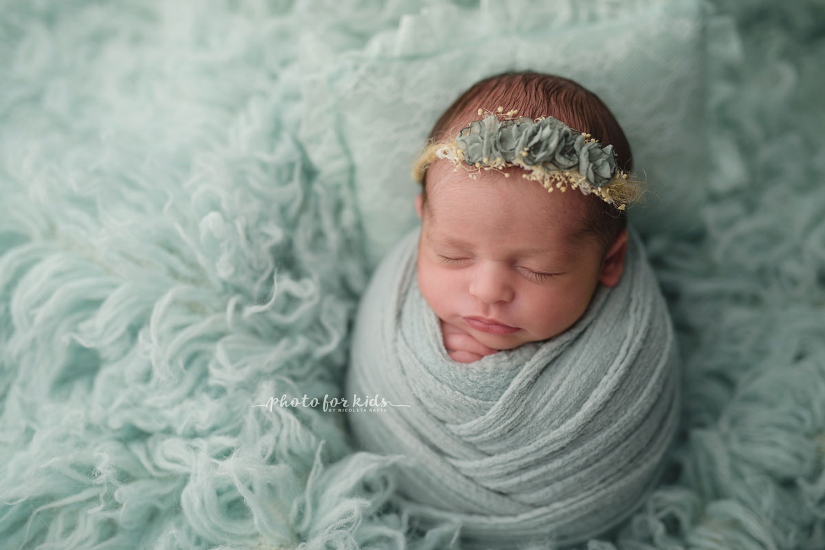 new born baby girl in green wrap and flowers diadem during a photo session in photography workshop by Nicoleta Raftu