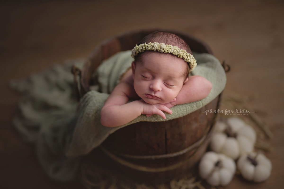 new born girl sleeps in a basket with head on her hands during a workshop by Nicoleta Raftu