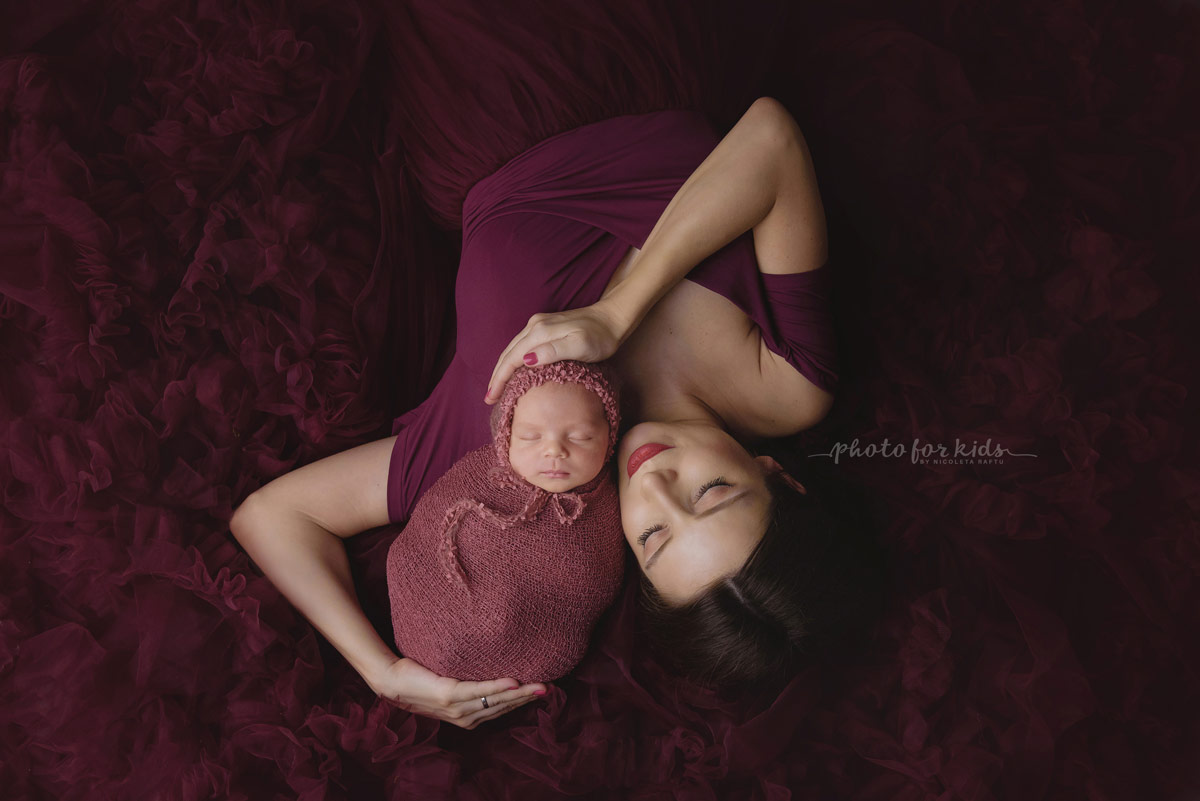 newborn sleeps in arms of mother during new born workshop by Nicoleta Raftu