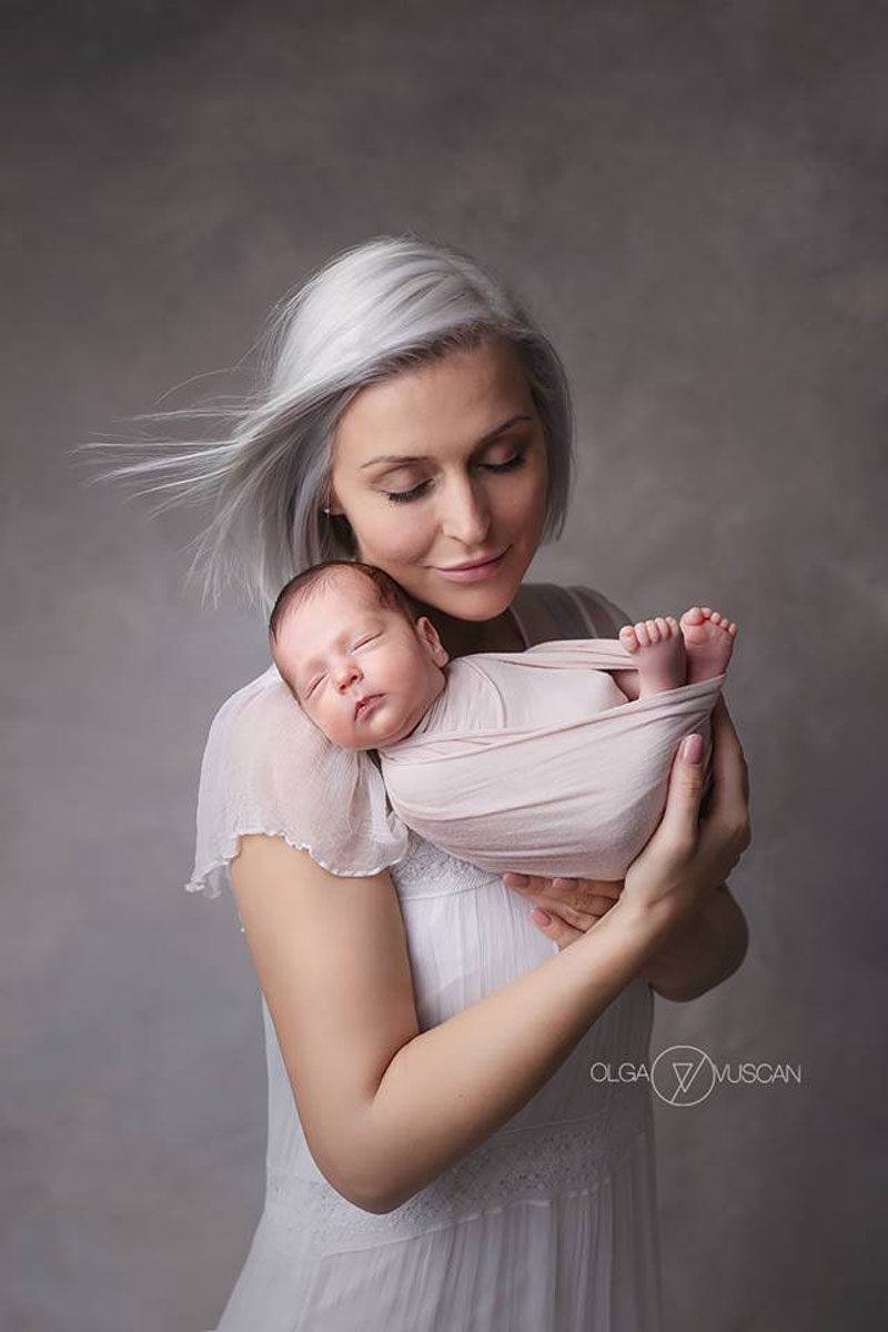 Olga Vuscan New Born Photographer for Workshops by Camen Bergmann Studio mother with white dress and white dyed hair hold her new born baby